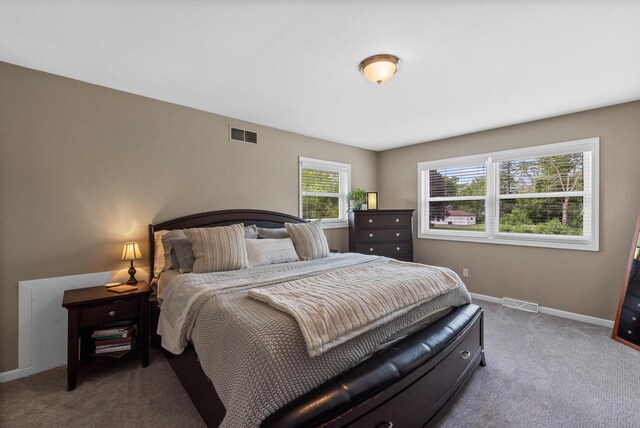 carpeted bedroom featuring baseboards and visible vents
