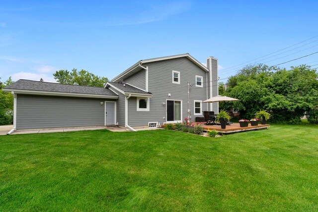 rear view of house featuring a chimney, a yard, and a deck