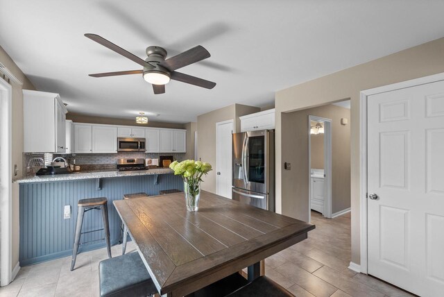 dining room with baseboards and a ceiling fan