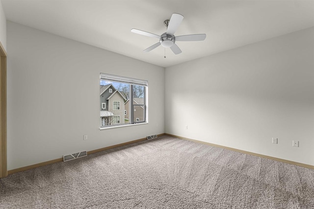 carpeted empty room featuring baseboards, visible vents, and ceiling fan