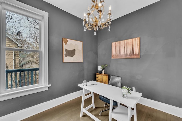 office area featuring an inviting chandelier, baseboards, and wood finished floors
