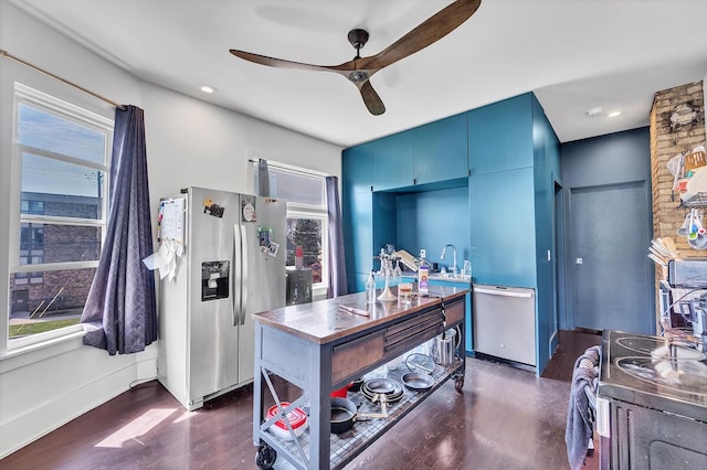 office area featuring dark wood-type flooring, ceiling fan, and a healthy amount of sunlight