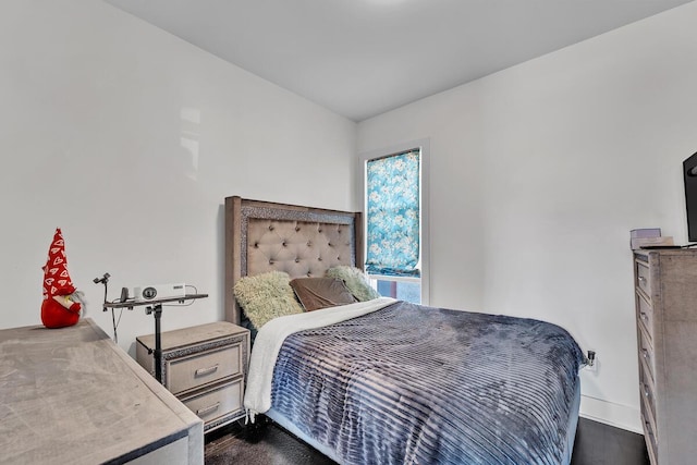bedroom featuring baseboards and dark wood-style flooring
