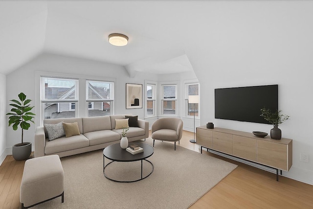 living area with baseboards, wood finished floors, and vaulted ceiling