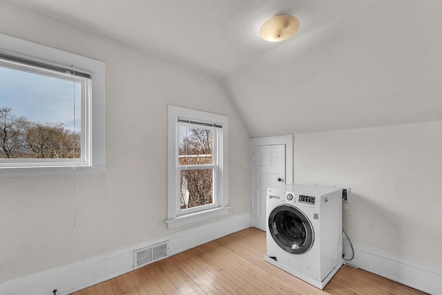 washroom featuring laundry area, washer / clothes dryer, baseboards, visible vents, and hardwood / wood-style flooring