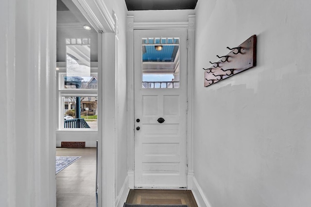 doorway to outside featuring baseboards and wood finished floors
