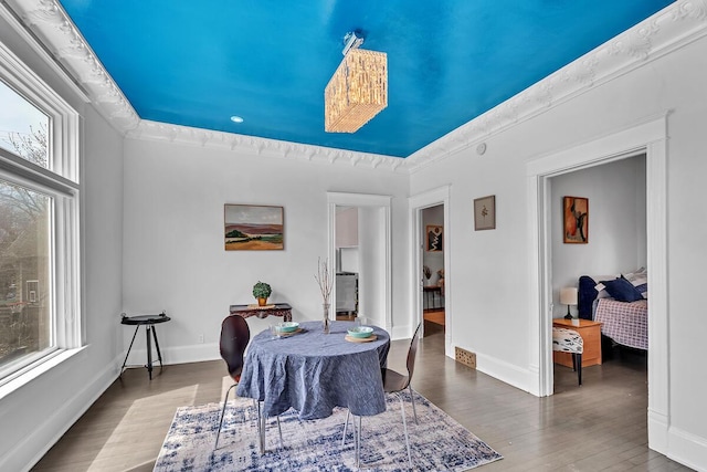 dining space with baseboards and wood finished floors