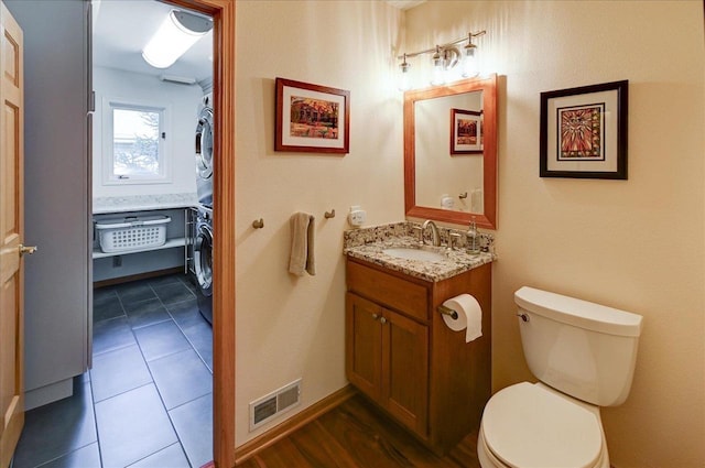 6610 Whittlesey Rd, Middleton, WI 53562 - bathroom with stacked washer and clothes dryer, vanity, toilet, and baseboards