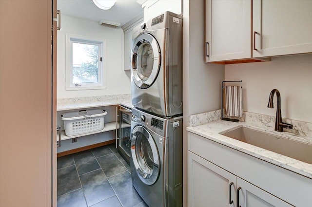 6610 Whittlesey Rd, Middleton, WI 53562 - laundry area with stacked washer / drying machine, cabinet space, and dark tile patterned flooring