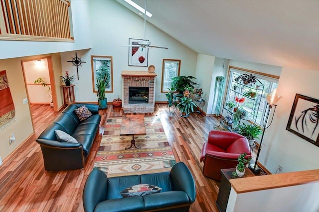 6610 Whittlesey Rd, Middleton, WI 53562 - living area featuring wood finished floors, high vaulted ceiling, a brick fireplace, ceiling fan, and baseboards