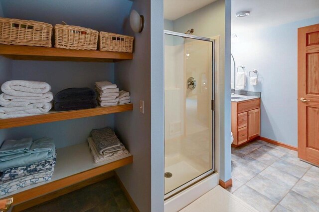 6610 Whittlesey Rd, Middleton, WI 53562 - bathroom with a shower stall, baseboards, tile patterned floors, and vanity