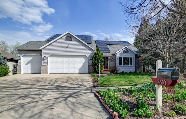 6610 Whittlesey Rd, Middleton, WI 53562 - view of front of home with brick siding, a garage, concrete driveway, a front yard, and solar panels