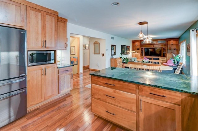 6610 Whittlesey Rd, Middleton, WI 53562 - kitchen with appliances with stainless steel finishes, light wood-style flooring, open floor plan, hanging light fixtures, and dark stone countertops