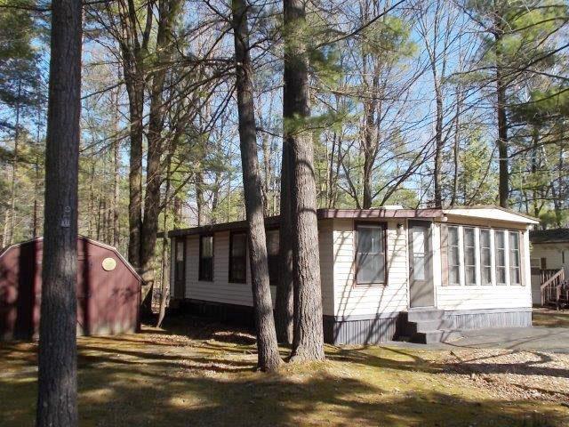 view of side of property with entry steps, an outbuilding, and a shed