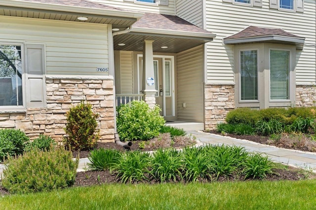 7605 W Windrush Ln, Franklin, WI 53132 - entrance to property with stone siding, a shingled roof, and a porch