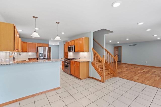 7605 W Windrush Ln, Franklin, WI 53132 - kitchen featuring stainless steel appliances, recessed lighting, backsplash, light stone counters, and a peninsula