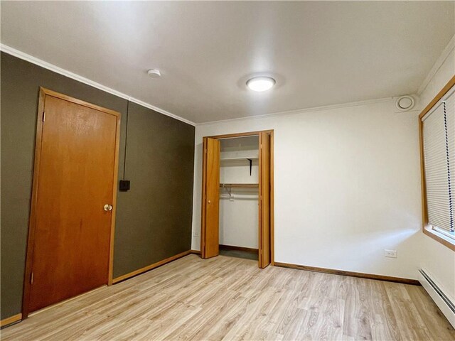 7672 178th St, Chippewa Falls, WI 54729 - unfurnished bedroom with baseboard heating, light wood finished floors, crown molding, a closet, and baseboards