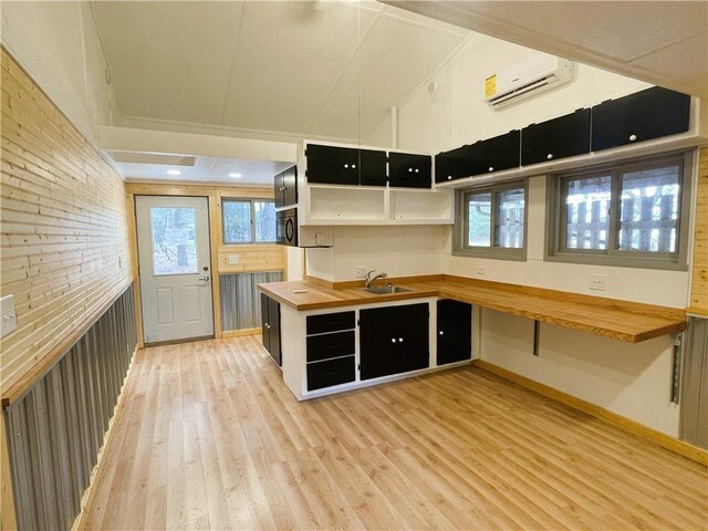 7672 178th St, Chippewa Falls, WI 54729 - kitchen featuring wood counters, an AC wall unit, light wood-type flooring, a sink, and open shelves