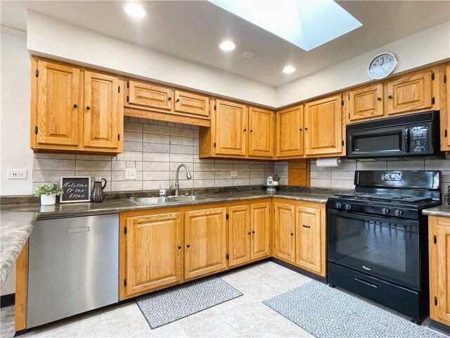 7672 178th St, Chippewa Falls, WI 54729 - kitchen with black appliances, a sink, a skylight, backsplash, and dark countertops