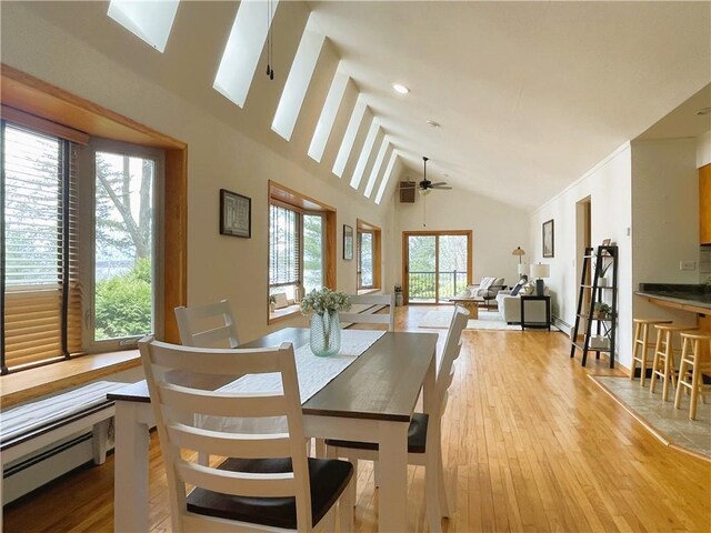 7672 178th St, Chippewa Falls, WI 54729 - dining room featuring a baseboard radiator, light wood-style floors, a skylight, a ceiling fan, and high vaulted ceiling