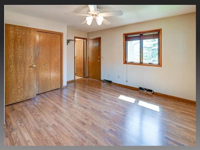 5401 Comanche Way, Madison, WI 53704 - unfurnished bedroom with light wood finished floors, multiple closets, baseboards, and a ceiling fan