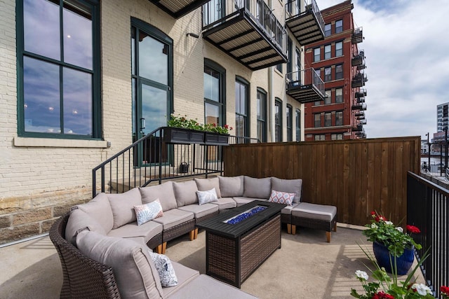 view of patio / terrace featuring an outdoor living space with a fire pit and fence