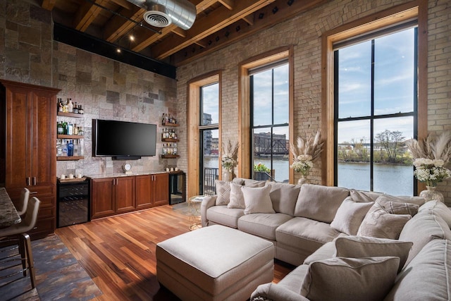 living room featuring indoor bar, light wood-type flooring, plenty of natural light, and visible vents