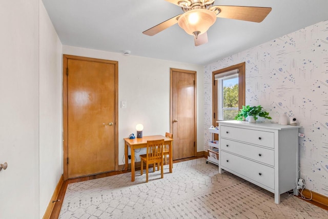 interior space with baseboards, a ceiling fan, and wallpapered walls