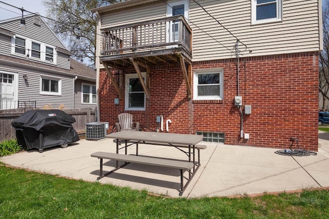 rear view of property featuring brick siding, cooling unit, fence, a balcony, and a patio