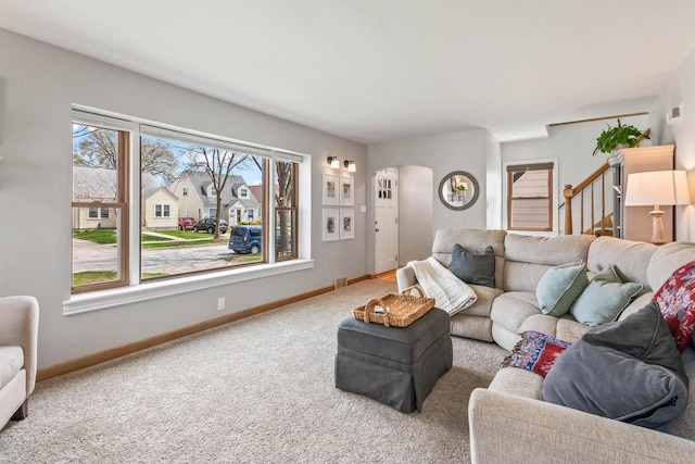 carpeted living room with baseboards, arched walkways, stairs, and visible vents