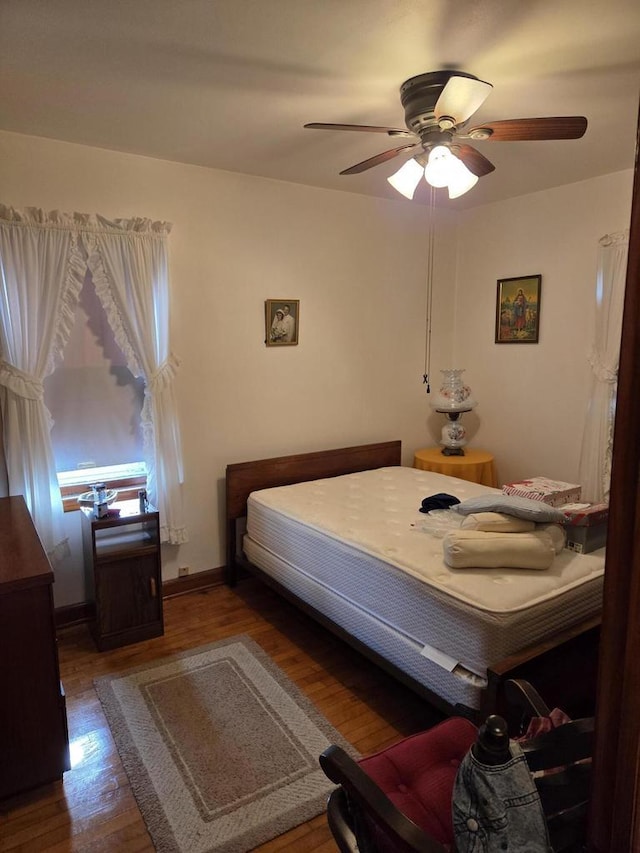 bedroom with baseboards, a ceiling fan, and wood finished floors