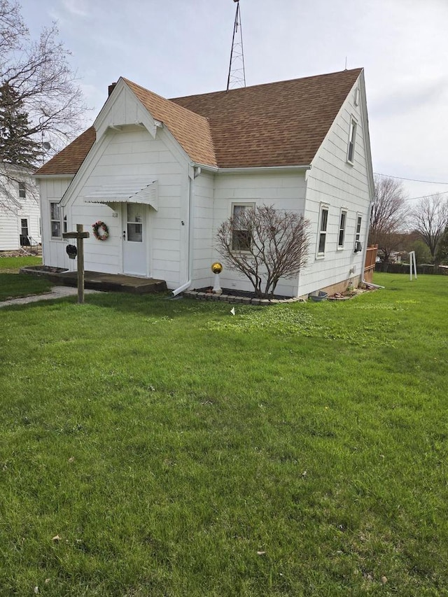 view of front of property featuring a front yard and roof with shingles