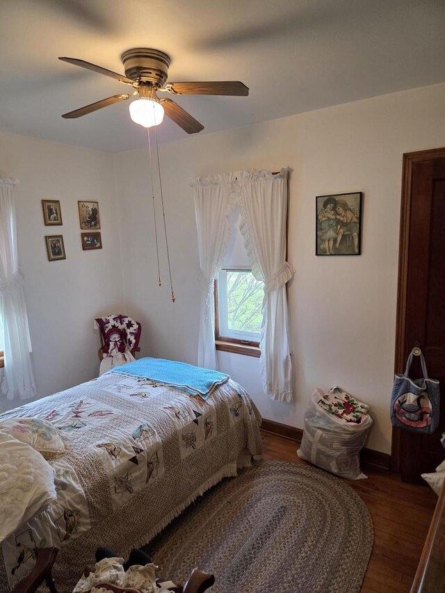 bedroom with baseboards, ceiling fan, and wood finished floors