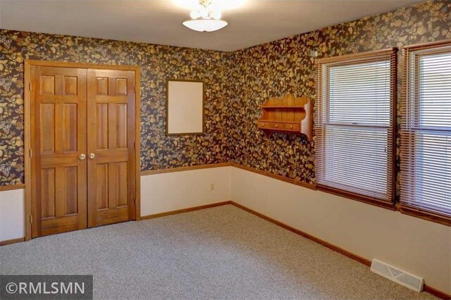 890 Lincoln Ave, Amery, WI 54001 - spare room featuring carpet floors, baseboards, wallpapered walls, and visible vents