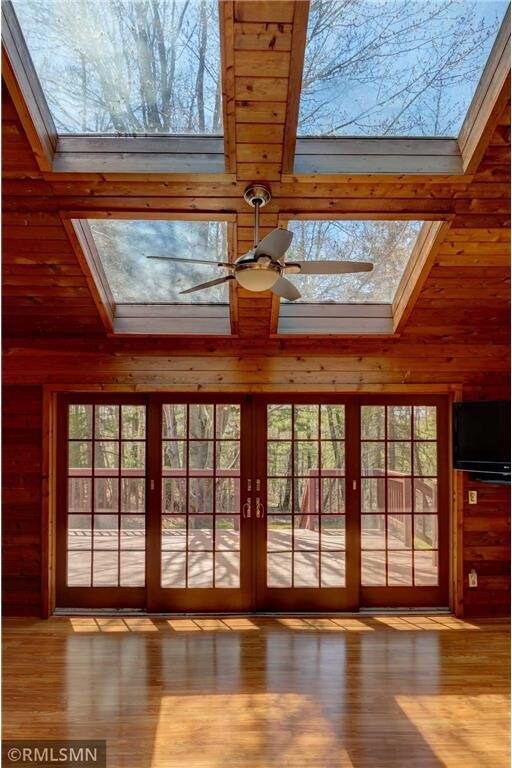 890 Lincoln Ave, Amery, WI 54001 - entryway featuring wood walls, a ceiling fan, wood finished floors, and a skylight