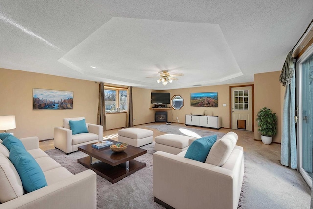 1992 London Rd, Green Bay, WI 54311 - living area with ceiling fan, a textured ceiling, light carpet, a tray ceiling, and a wealth of natural light