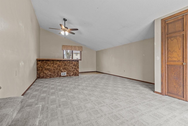 interior space featuring carpet floors, ceiling fan, lofted ceiling, and visible vents