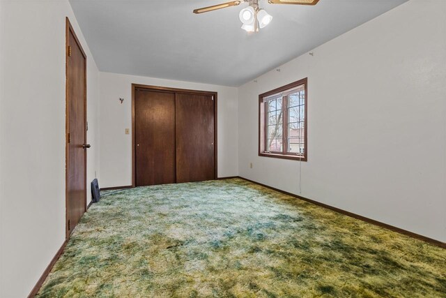 unfurnished bedroom featuring a closet, baseboards, a ceiling fan, and carpet flooring