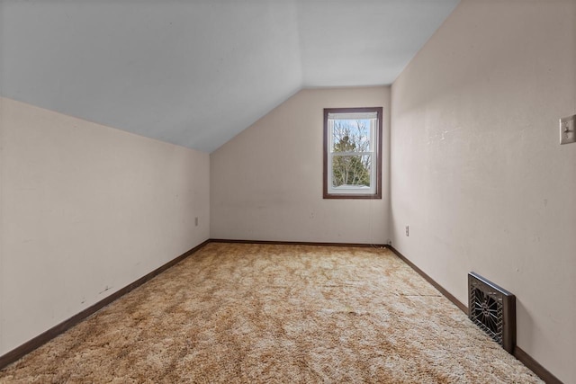 additional living space with carpet flooring, baseboards, visible vents, and lofted ceiling