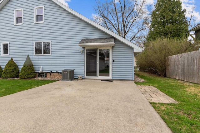 rear view of property with a patio, central AC unit, fence, and a yard