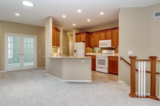 1111 Virgin Lake Dr, Stoughton, WI 53589 - kitchen with white appliances, light carpet, a sink, recessed lighting, and a peninsula