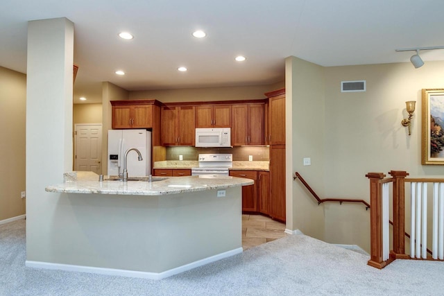 1111 Virgin Lake Dr, Stoughton, WI 53589 - kitchen with white appliances, light carpet, a sink, a peninsula, and recessed lighting