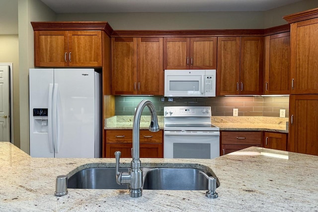 1111 Virgin Lake Dr, Stoughton, WI 53589 - kitchen with white appliances, a sink, light stone countertops, and brown cabinets