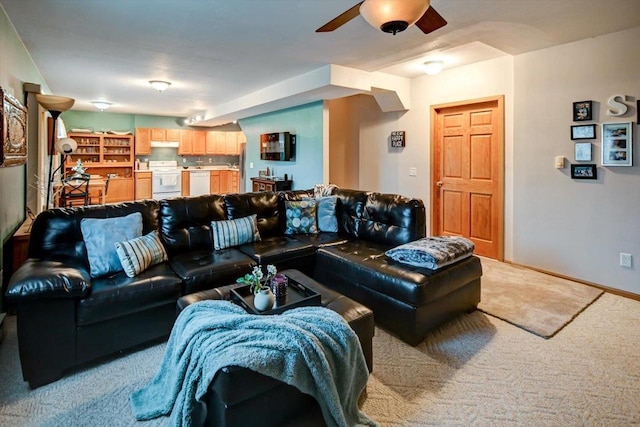 carpeted living room with baseboards and a ceiling fan