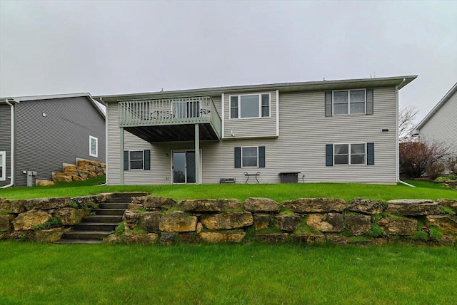 back of property with stairway, a lawn, and a balcony