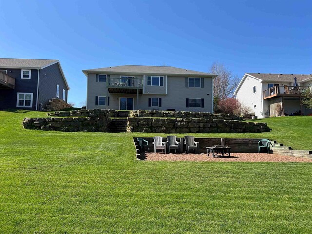 view of property's community with stairs, a yard, and an outdoor fire pit