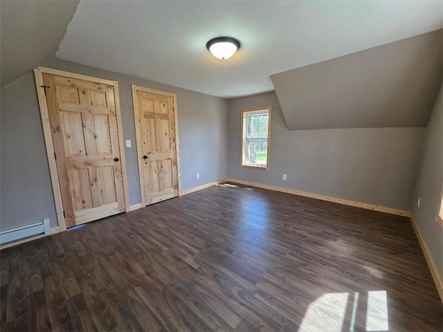 additional living space with baseboards, a baseboard radiator, vaulted ceiling, and dark wood finished floors