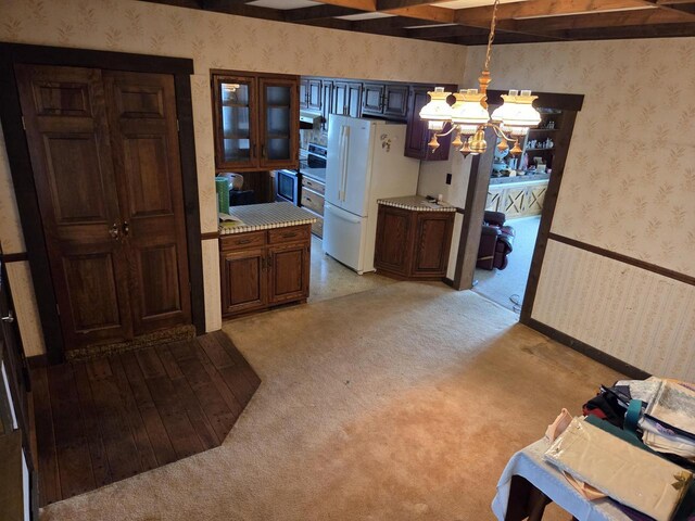 5986 Marsh Rd, Elkhorn, WI 53121 - dining area with light colored carpet, beam ceiling, a notable chandelier, and wallpapered walls