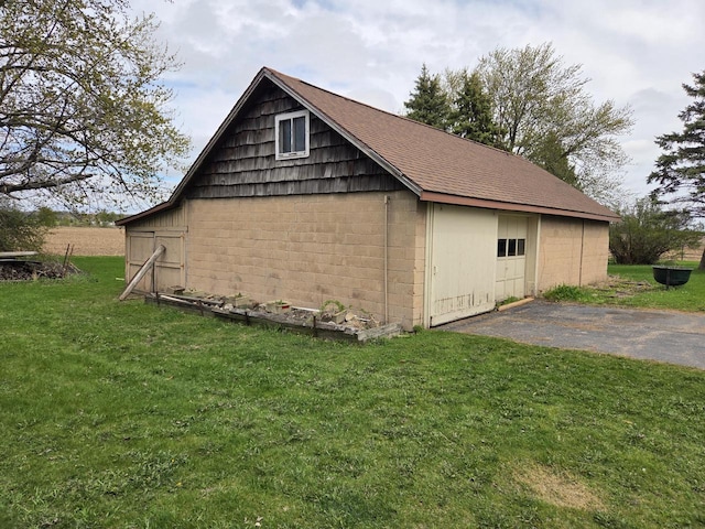 5986 Marsh Rd, Elkhorn, WI 53121 - view of home's exterior with a lawn, a shingled roof, concrete block siding, and an outbuilding
