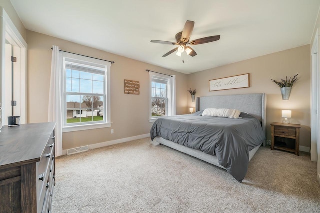 carpeted bedroom featuring baseboards, visible vents, and ceiling fan